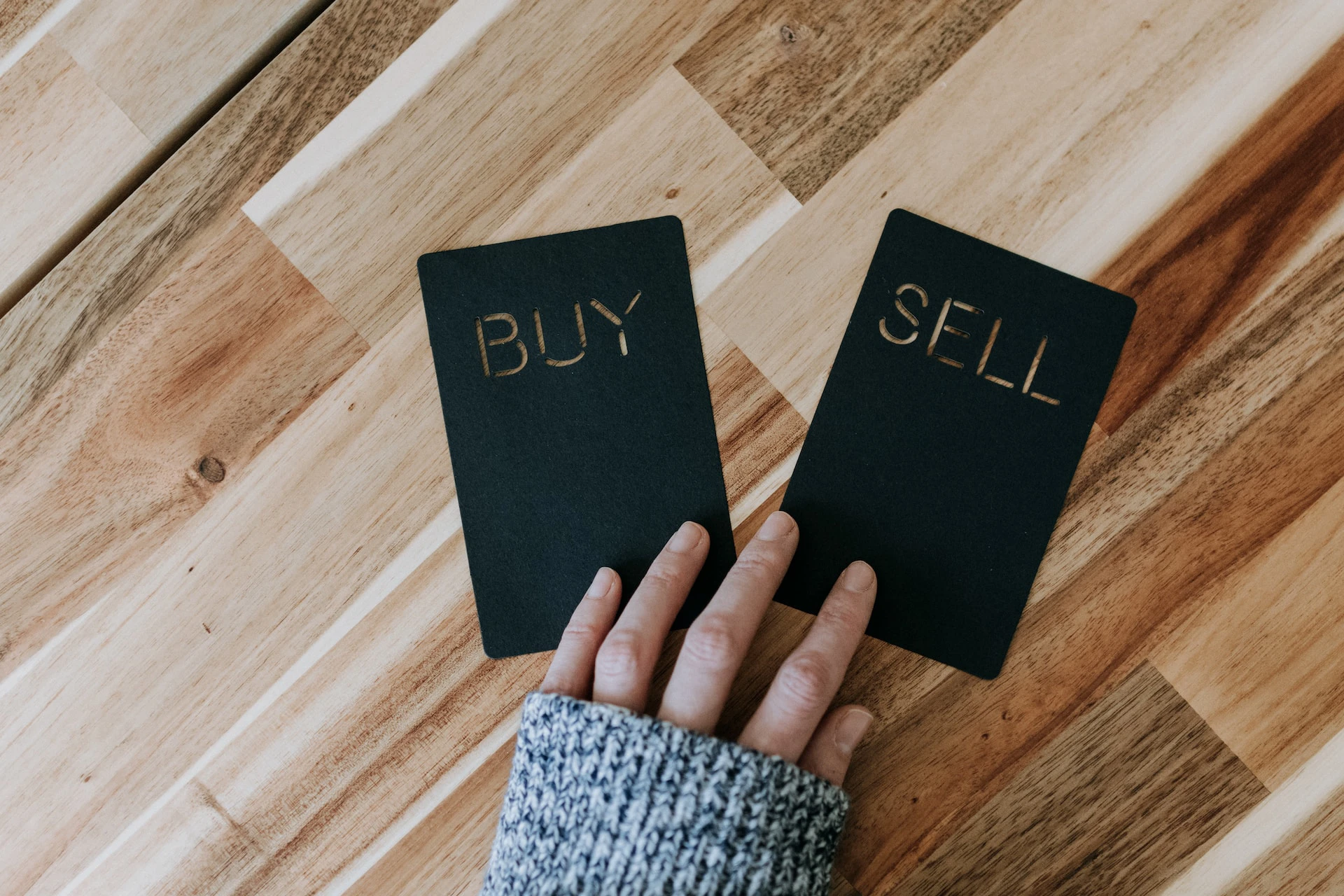 hand holding a buy and sell sign on the floor